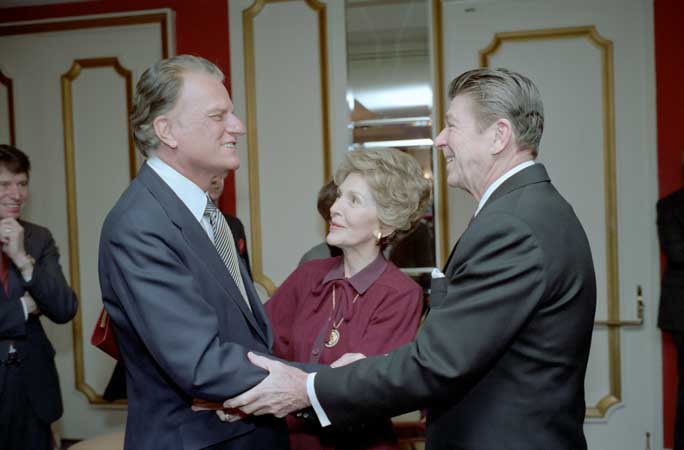 President Ronald Reagan and First Lady Nancy Reagan greet Billy Graham at the National Prayer Breakfast held at the Washington Hilton Hotel on February 5, 1981. (Photo Credit: White House Photo Office)