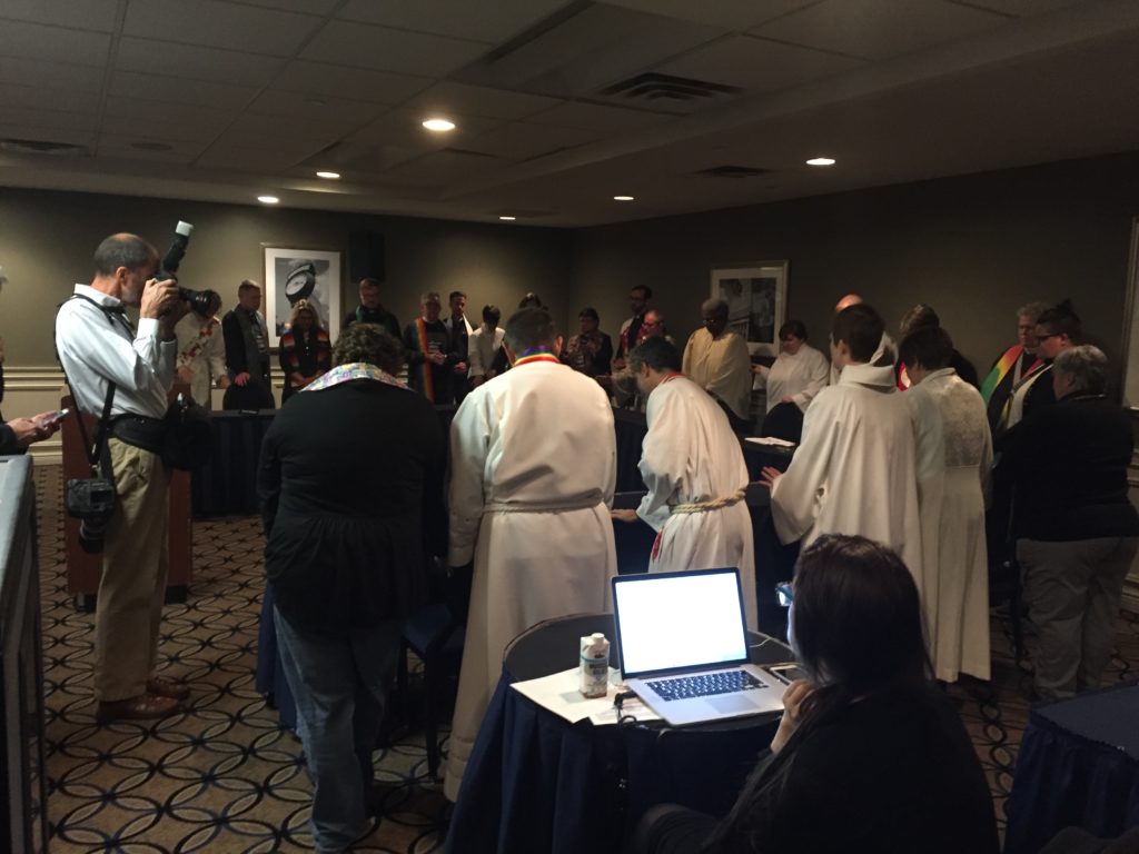 LGBTQ clergy surrounded the Judicial Council's tables prior to the session.